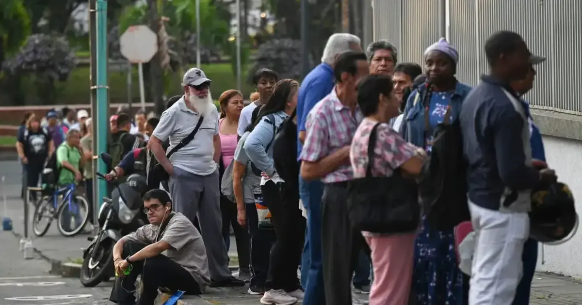 ¡Urgente! Carta Abierta a Nuestra Conciencia Democrática 2 Ciudadanos colombianos hacen largas filas frente a un centro de salud esperando medicamentos, reflejando la crisis sanitaria y la falta de acceso al sistema de salud.
