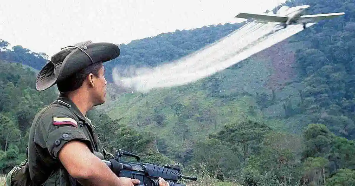 ¡Alarmante! Santos, La Violencia Y El Narcotráfico 3 Policía antinarcóticos colombiano observa una avioneta fumigando cultivos ilícitos en zona rural, símbolo de la erradicación aérea y la lucha contra la violencia y el narcotráfico.