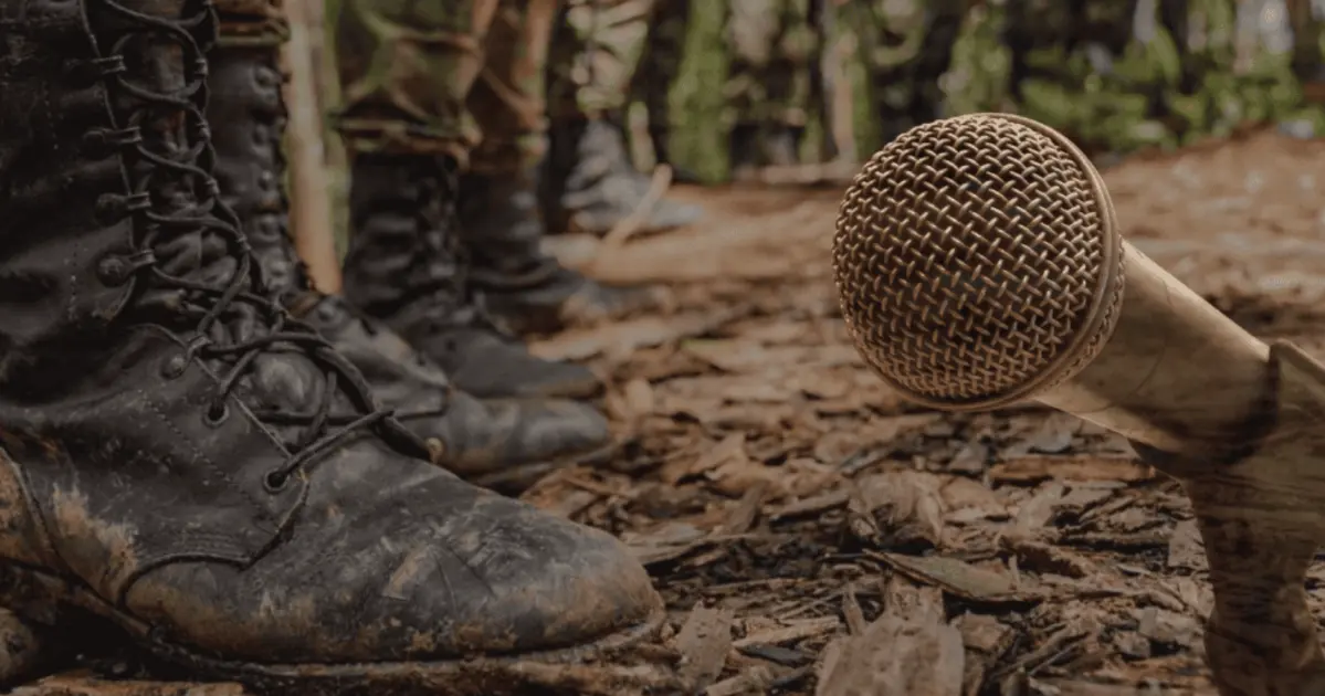 La libertad de prensa bajo violencia: asesinatos, exilios, desplazamientos, agresiones, ataques y amenazas 2 Micrófono caído en el suelo frente a botas militares en zona rural, símbolo de riesgo y amenaza contra la libertad de prensa en Colombia.